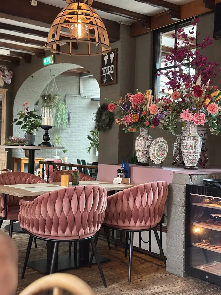 Het interieur van Le Jardin met roze fluwelen stoelen
